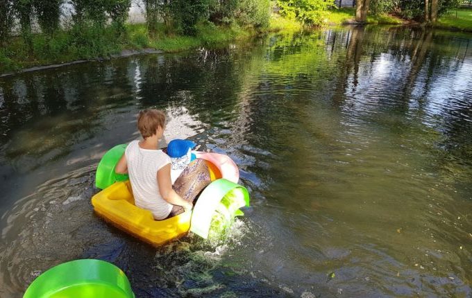 Tommys turbulente Tobewelt - Frau fährt im kleinen Boot mit Kind übers Wasser